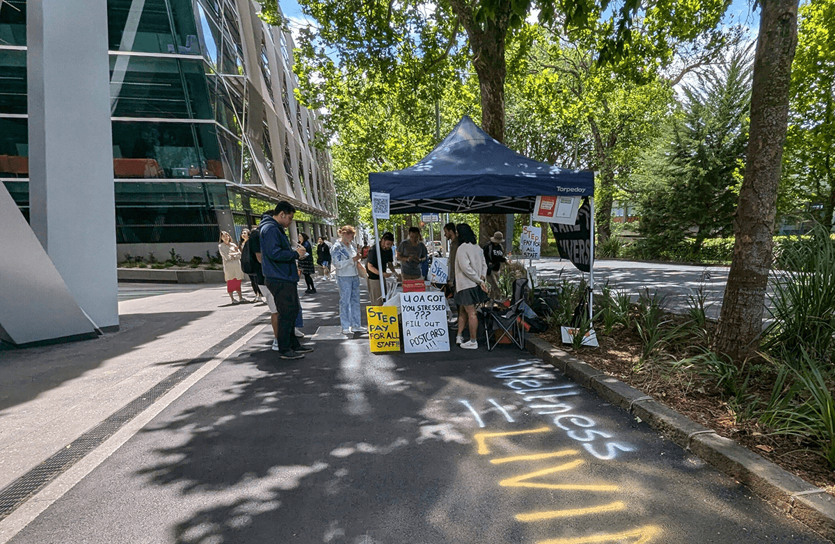 gazebo and people with placards on the pavement outside