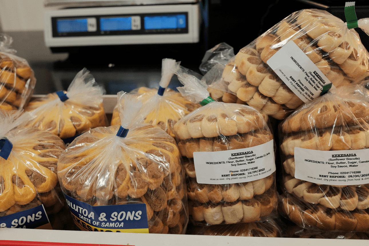 Clear bags of biscuits shaped as flowers on a bench, the bags are tied with rubber bands