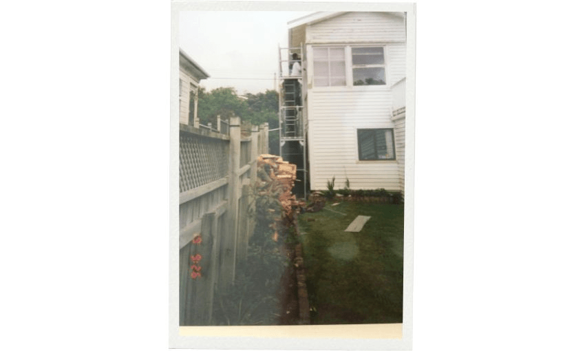 A picture of portrait showing a high scaffold over a house with people painting it