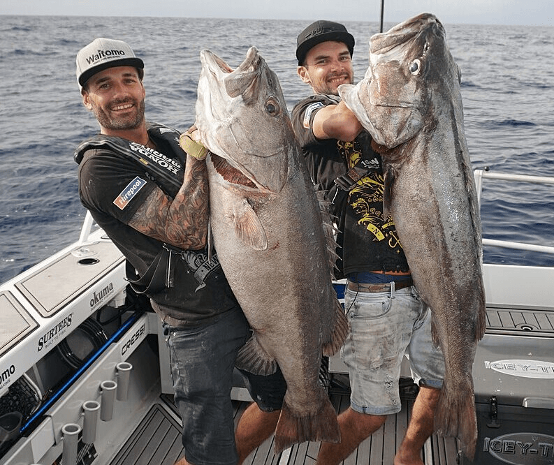 phot of two men holding very large fish