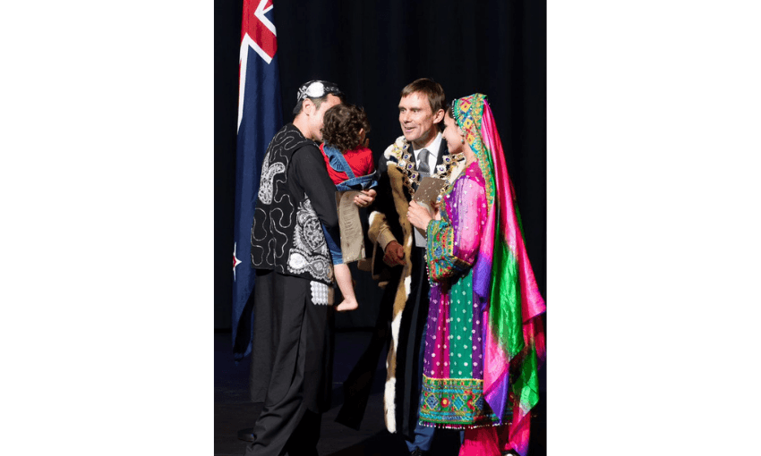 A photo of former mayor of Wellington Andy Foster with an Afghan family receiving citizenship.