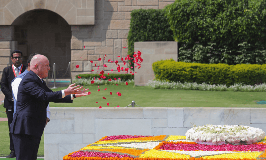 Christopher Luxon scatters rose petals at the Mahatma Gandhi memorial at Rajghat in New Delhi. Photo by AFP via Getty Images 
