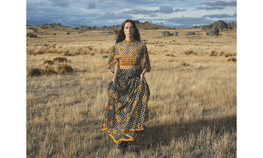 Photograph of model Ngahuia Williams in long dress, with central otago background.
