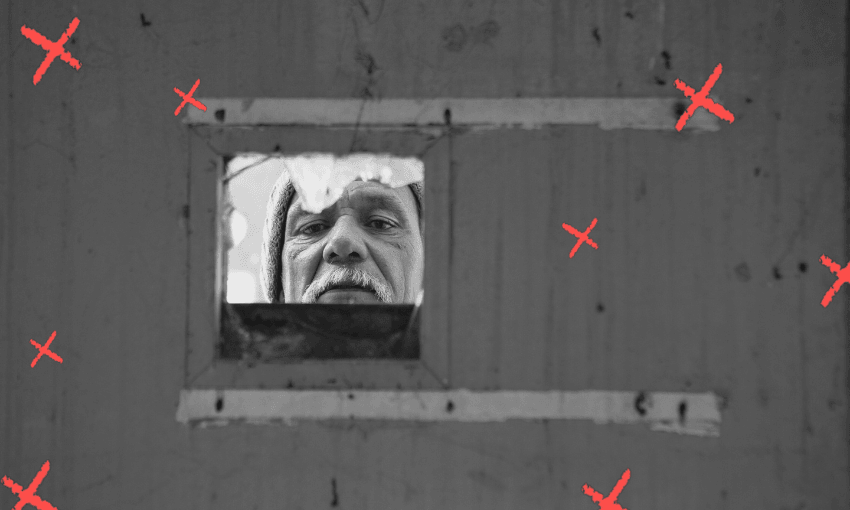 A man peers through a small square opening in a wall, his face framed by the window. The black-and-white image has red X marks scattered across the surface.