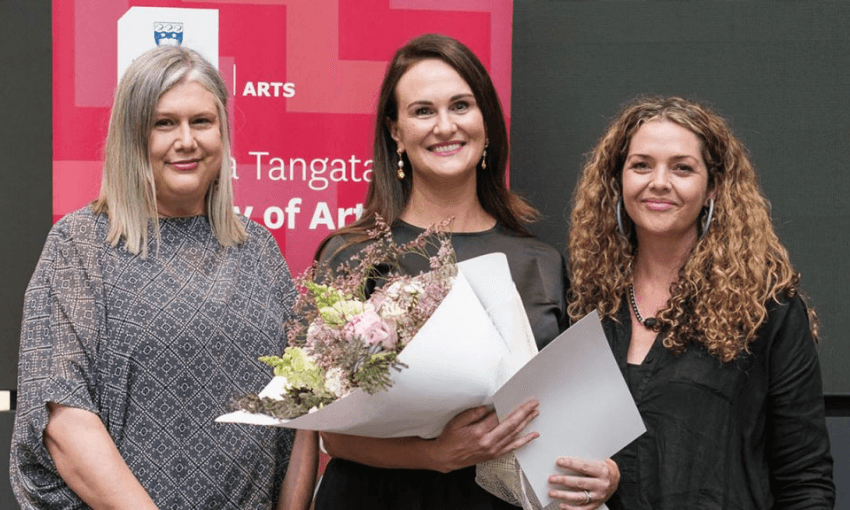 Photography of author Rachel Paris holding flowers, with her teacher Paula Morris and alumna from the masters of creative writing, Sonya Wilson.