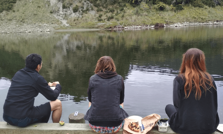 A photo of three people having a picnic by the Whanganui River.
