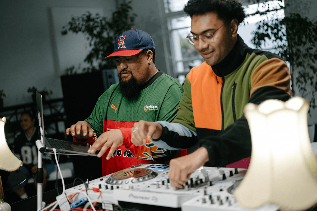 two men smiling at the DJ decks