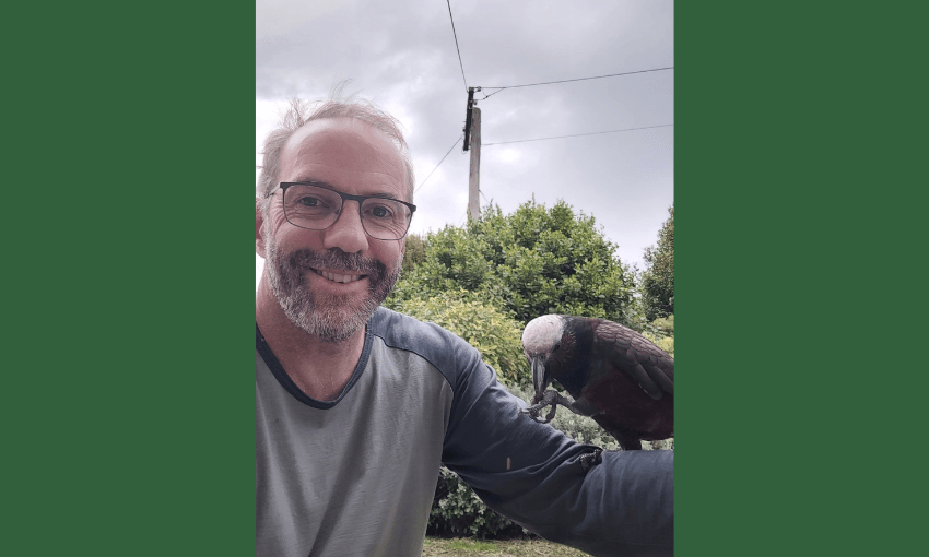 brent beaven, a smilling white man with a grizzled beard has a bird perched on his arm