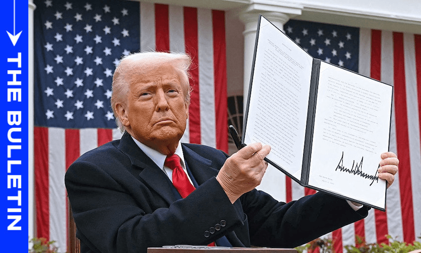 An older man with light hair in a dark suit and red tie holds up a signed document in an outdoor setting with American flags in the background. A blue banner on the left reads "The Bulletin.