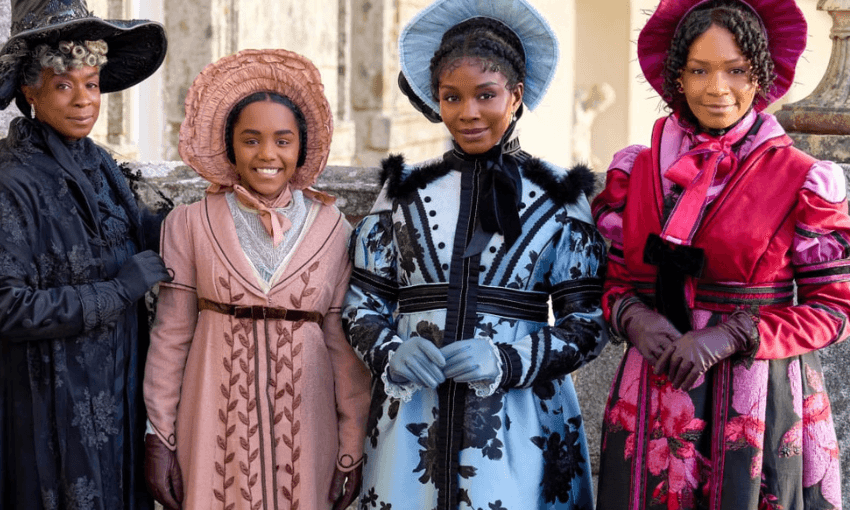 Four women stand in a line in bright Regency costume. They are the cast of the Hallmark Channel's Sense & Sensibility released in 2024. Susan Lawson-Reynolds (Mrs Dashwood), Beth Angus (Margaret Dashwood), Deborah Ayorinde (Elinor Dashwood), and Bethany Antonia (Marianne Dashwood). 