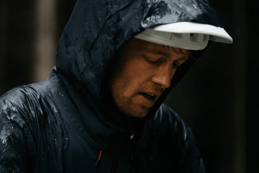 ben hildred looks a bit bleak in a black raincoat with a somber expression on his face 