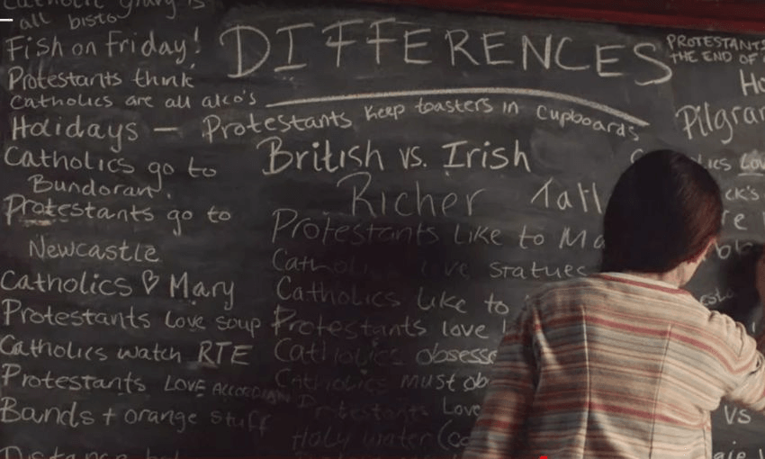 A scene from the show Derry Girls showing the differences between Catholics and Protestants written on a blackboard: "Catholics <3 Mary"