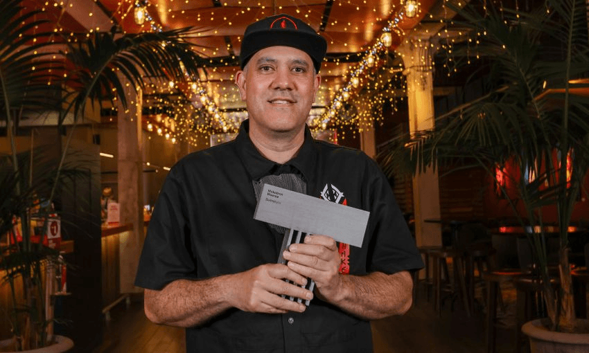 Musician Mokotron holding his Taite Music Prize award on the red carpet.