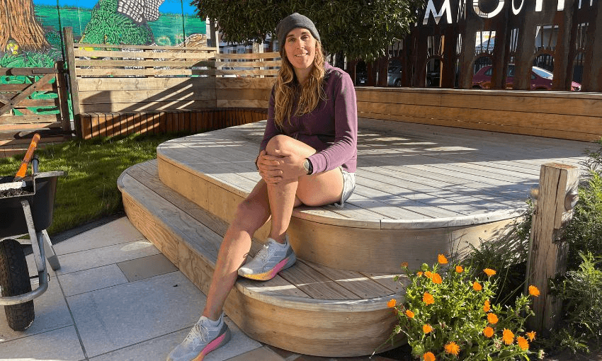 Cahoots founder Jade Musther sits on a platform outside her workshop in the sun.