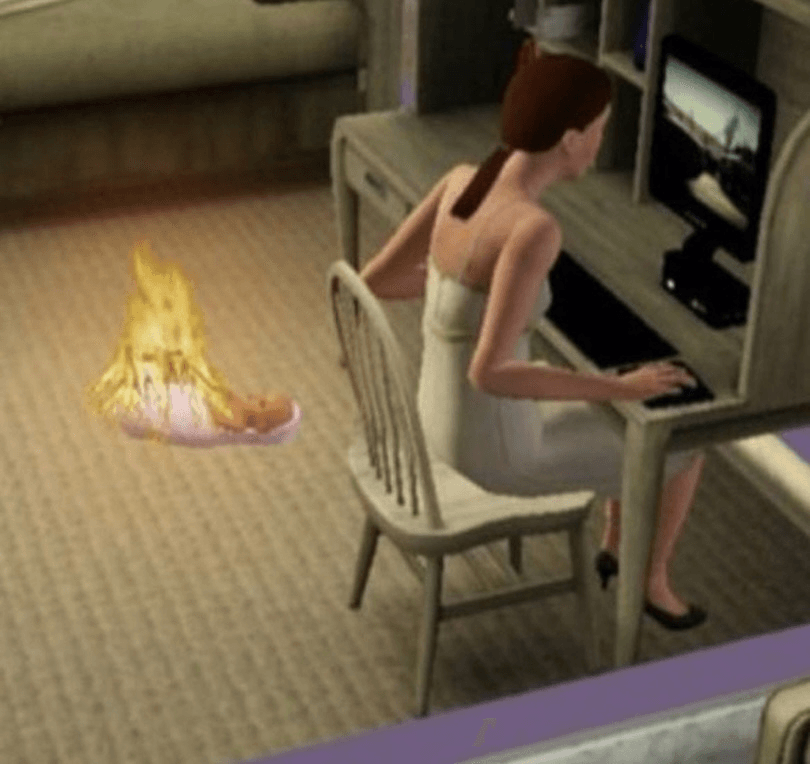 A computer-generated scene from a video game shows a woman in a dress using a desktop computer while a baby lies on the floor nearby, surrounded by flames. The woman appears unaware of the fire.