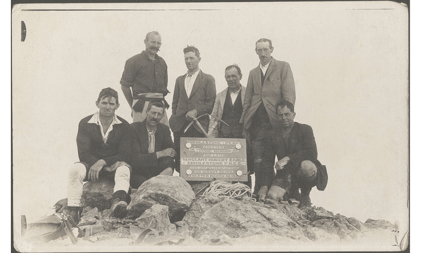 A sepia photograph of a group of men standing around a plaque erected in memory of their friend.