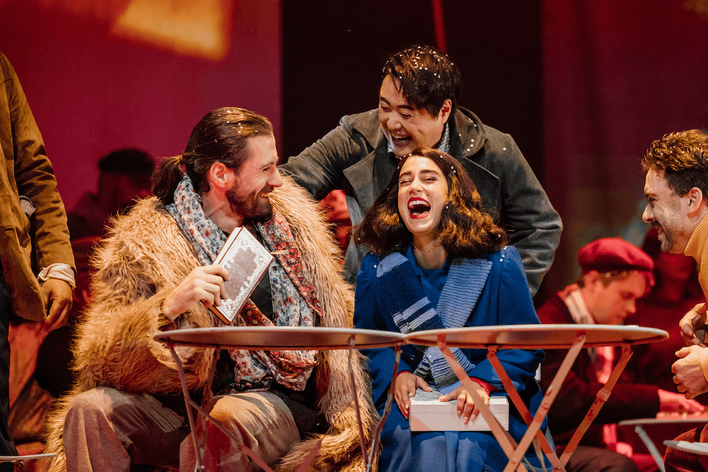 the cast of la boheme laughing on stage