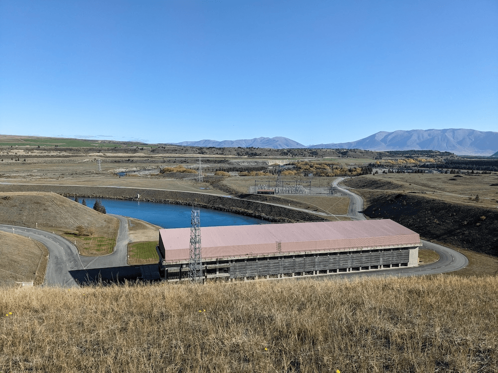 a blue sky and a building with a faded red roof and a turquoise canal