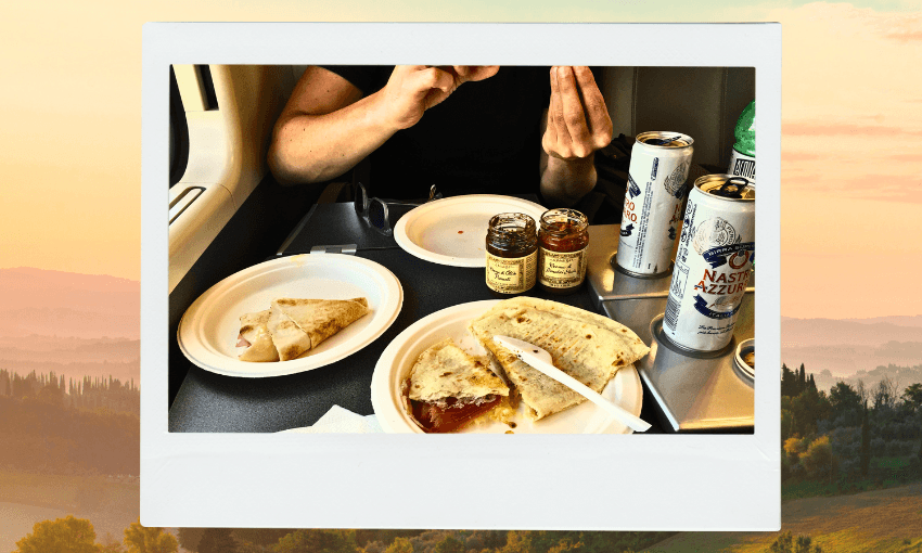 A person sits at a table on a train, eating flatbread with jars of jam and two cans of sparkling water. The table is covered with paper plates and utensils, and the scene is framed like a photo over a countryside background.