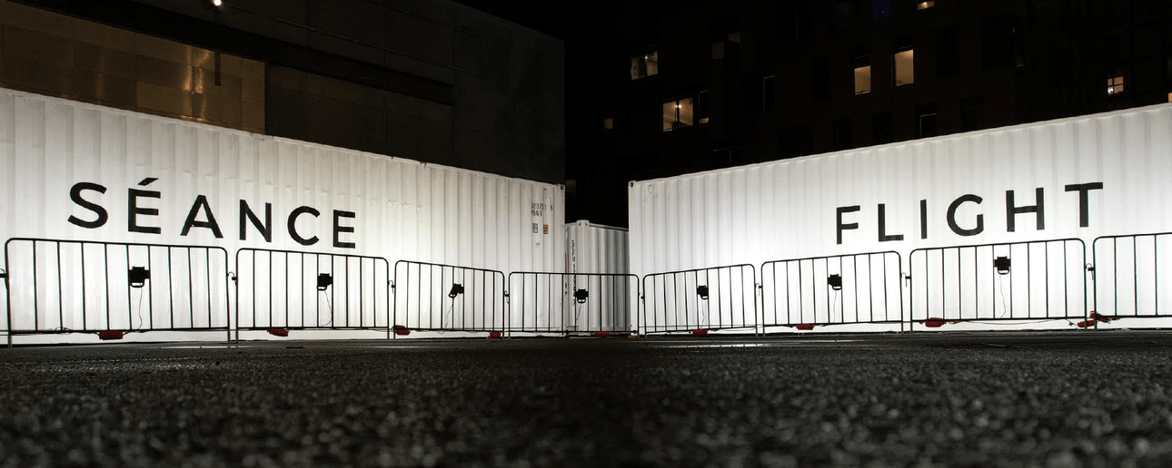 two white shipping containers in a dark square