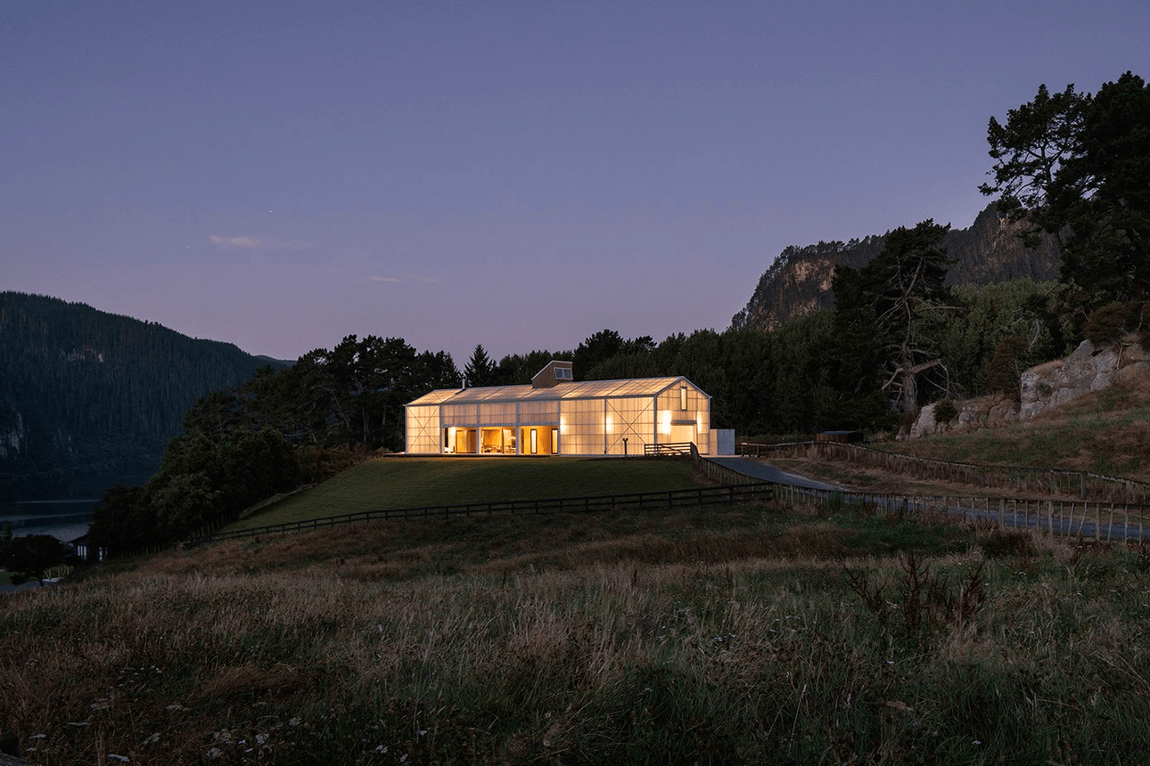 A seemingly translucent house lit up at dusk