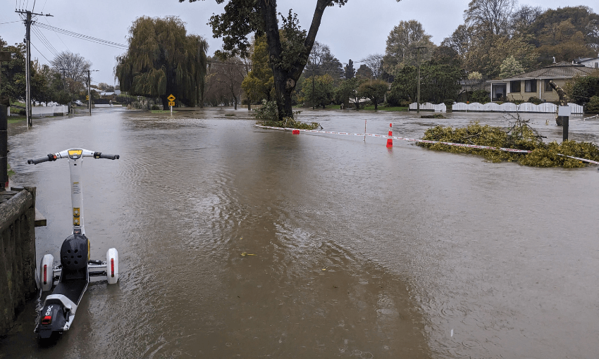 an escooter morosedly flooded with water covering a road in Beckenham on May 1 