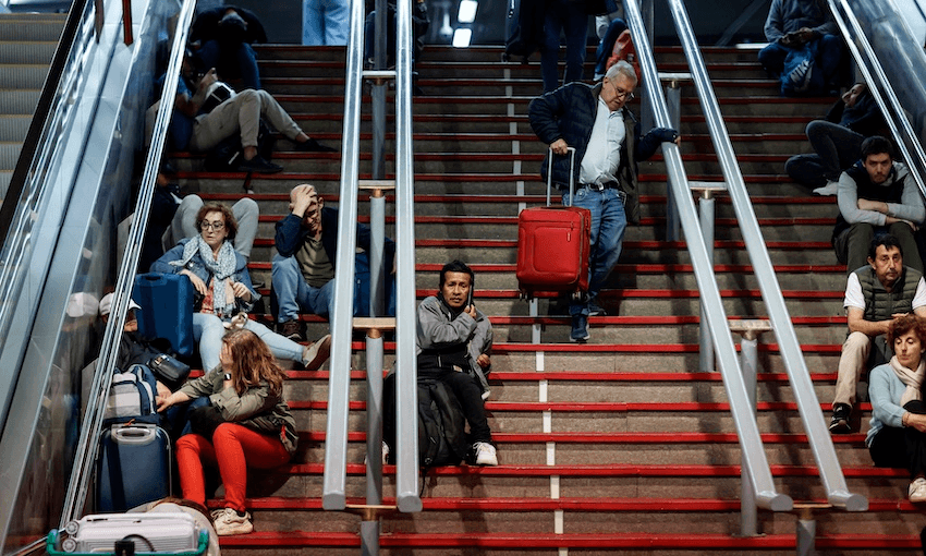 Travellers sit on the stairs at the Atocha train station in Madrid following a massive power cut affecting the entire Iberian peninsula and the south of France on April 28, 2025 (Photo: OSCAR DEL POZO/AFP via Getty Images) 
