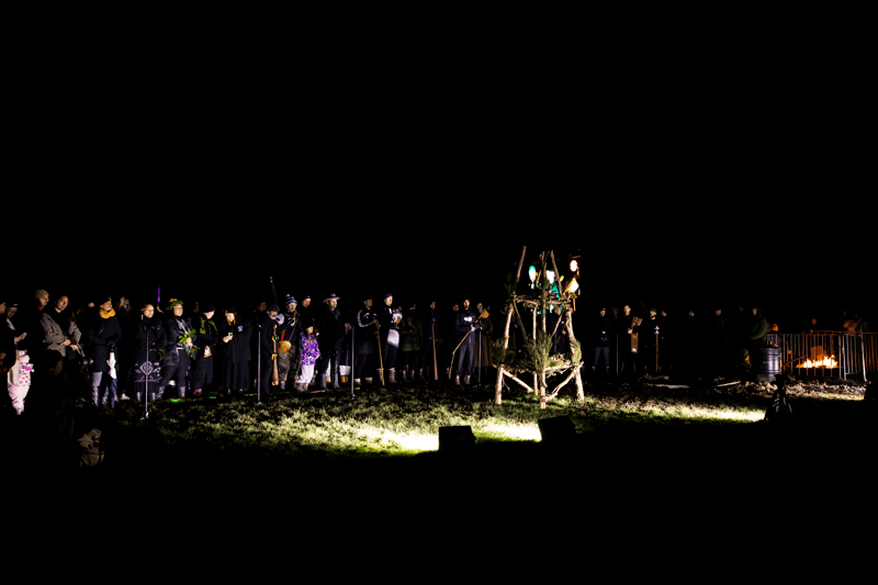 people gathered in darkness around a umu kohukohu whetū