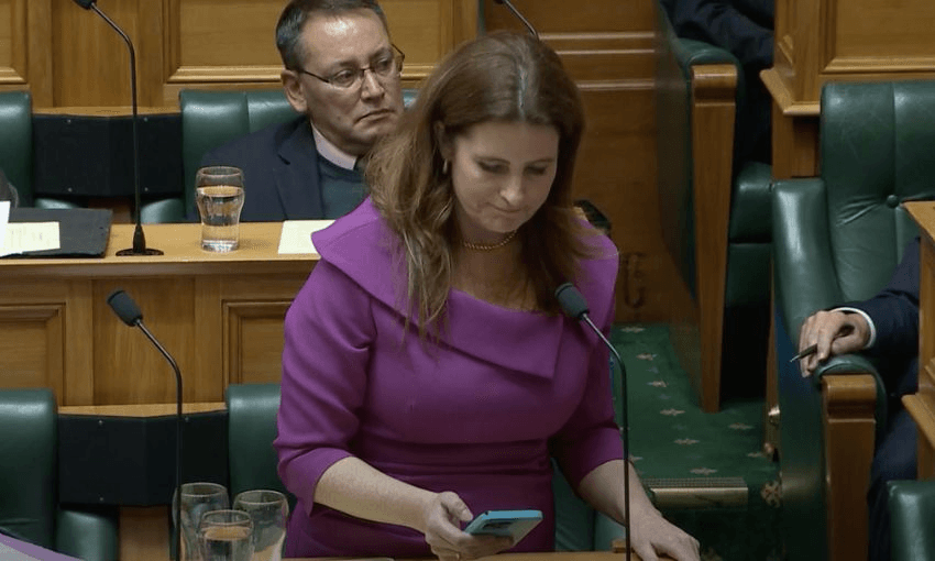 Nicola Willis looks at her phone while correcting herself in the House of Representatives.