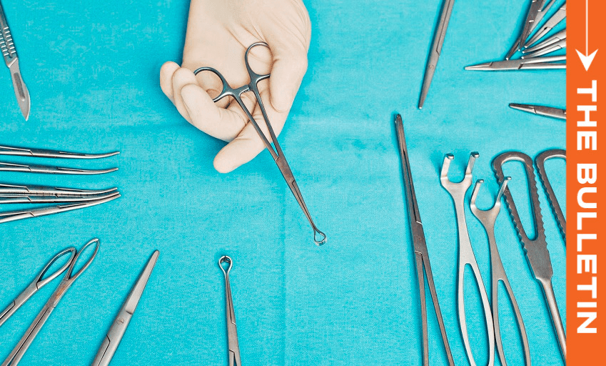A hand holds a surgical tool above a blue cloth covered with various surgical instruments; an orange vertical banner on the right reads "THE BULLETIN.
