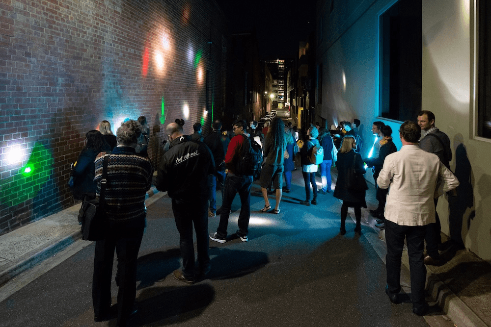 a group of people shining lights at the wall