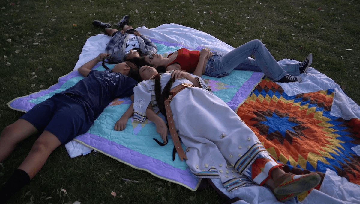 foud people lying on blankets outside on the grass