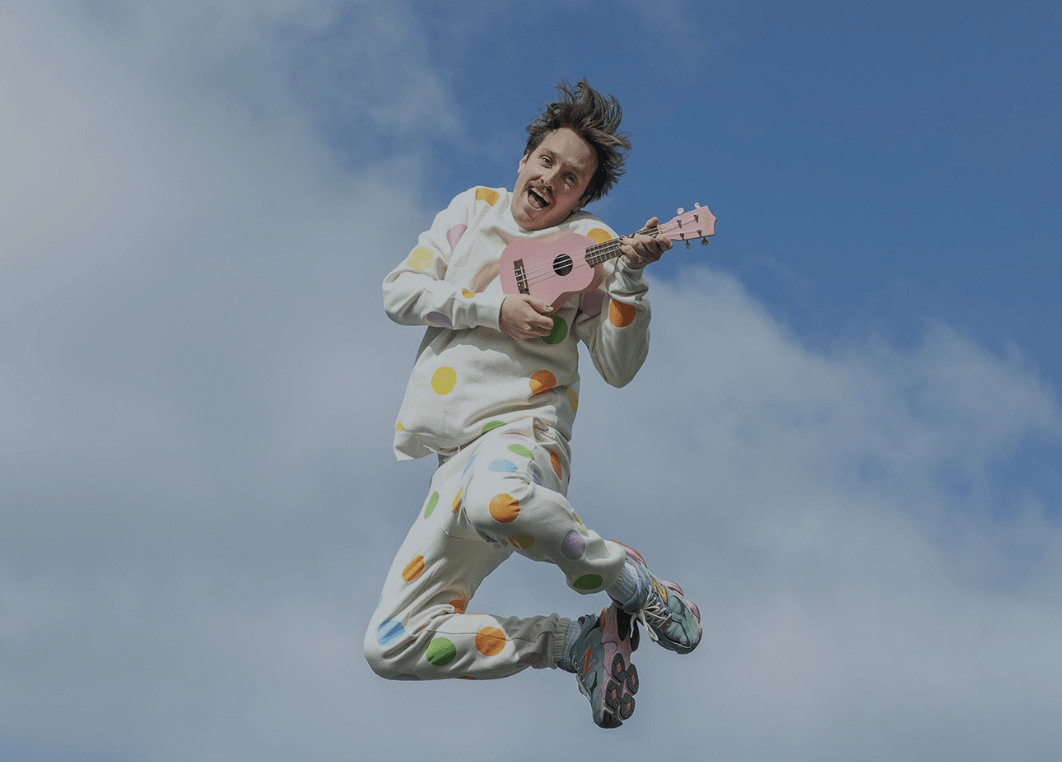 man jumping with ukulele