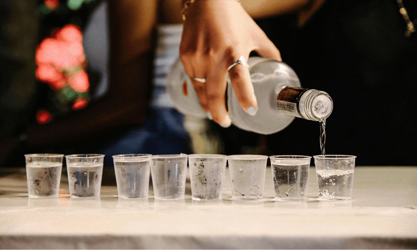 someone pouring shots from an icy vodka bottle