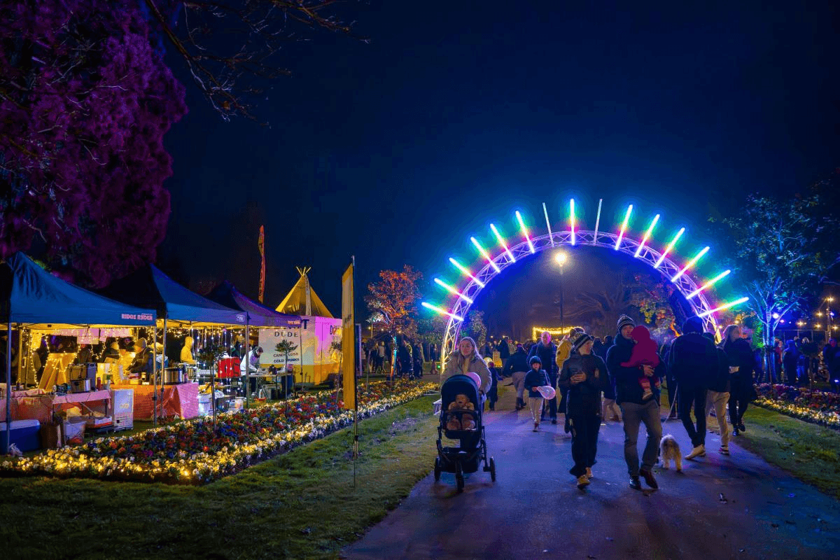 people in a park at night with many lights