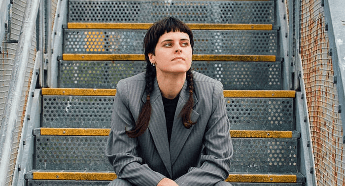 photo of a young woman sitting on industrial stairs