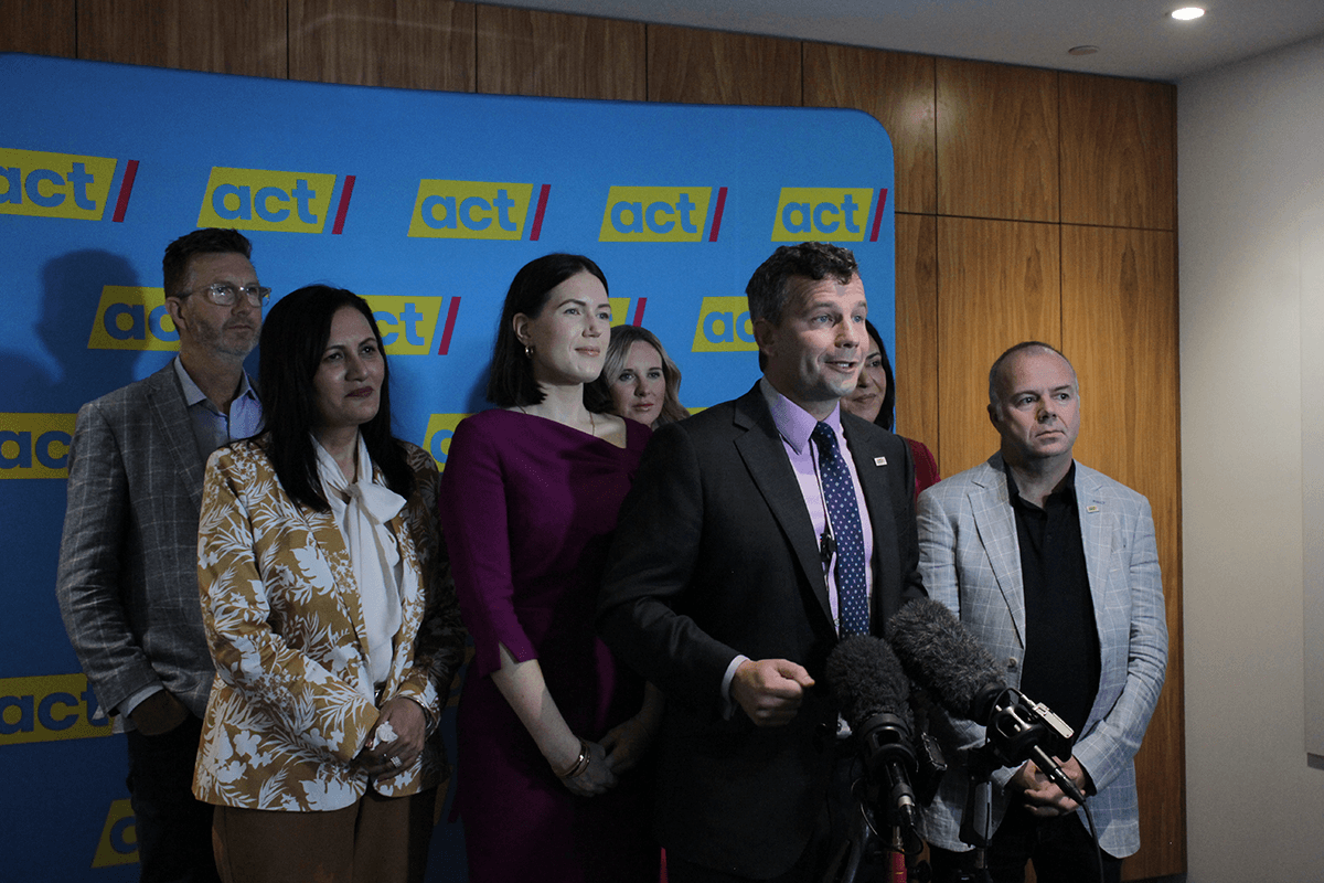 group of people headed by david seymour in front of Act Party banner