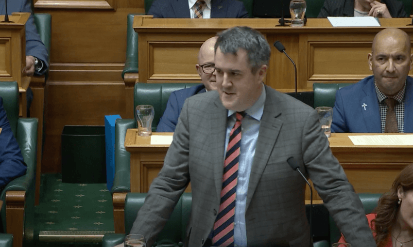 Chris Bishop addresses the House in a grey suit.