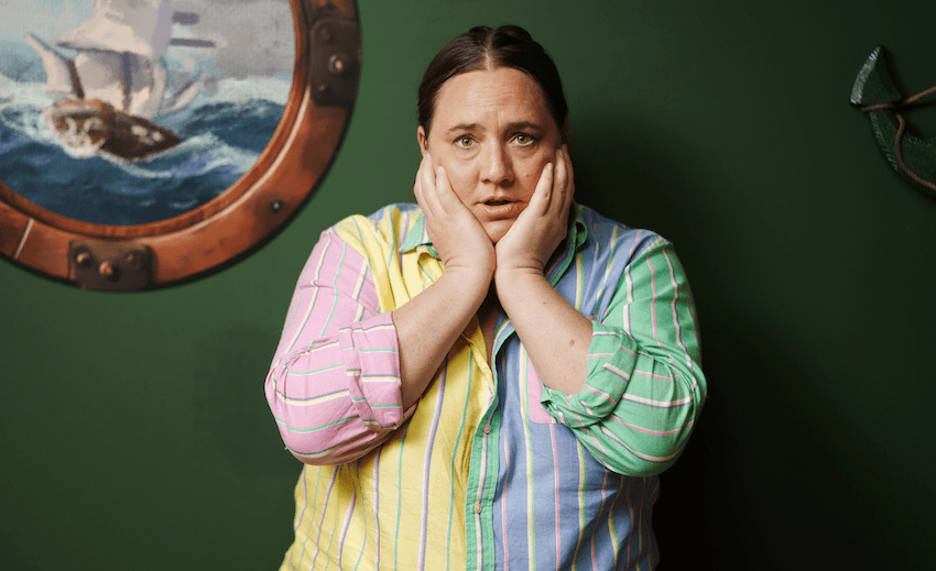 Alice Snedden wears a multicoloured pastel shirt and holds her face in her hands