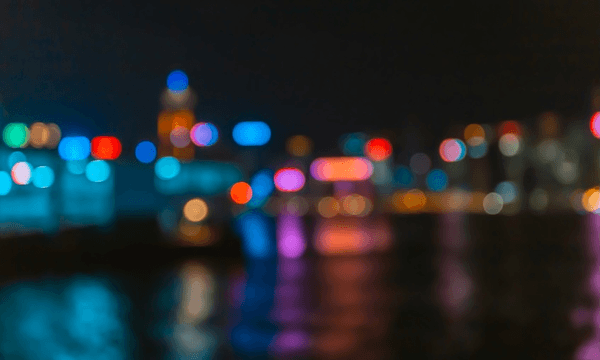 A city nightscape with a black sky and all the lights are fuzzy