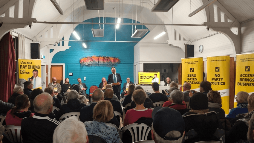 A man in a suit speaks to a crowd