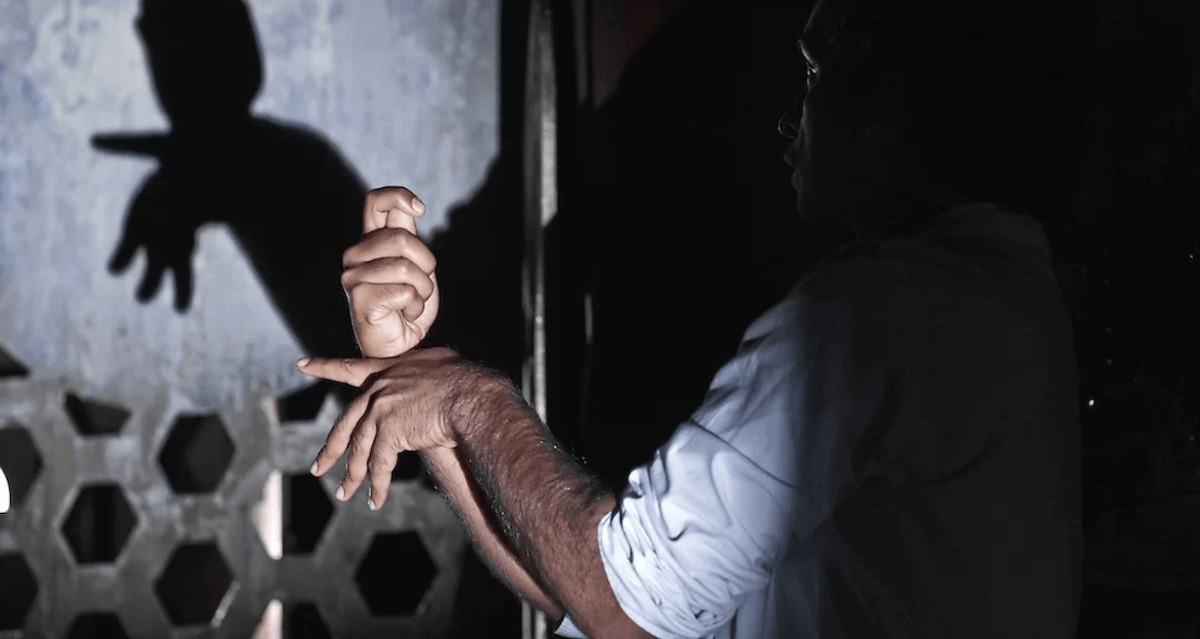 photo of a man's hands making shadow puppets