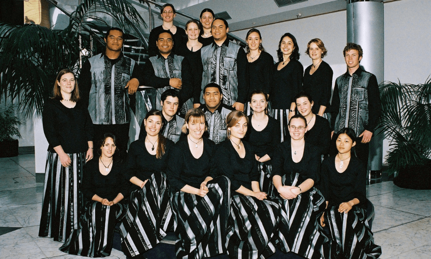 A choir portrait featuring about 20 young people of different ethnicities wearing black and silver uniforms