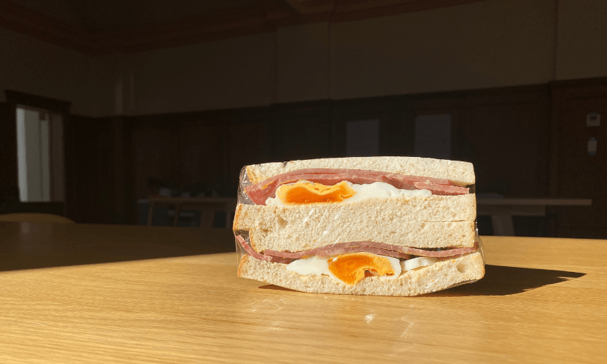 a bacon and egg sandwhich cut in half, sitting on a table