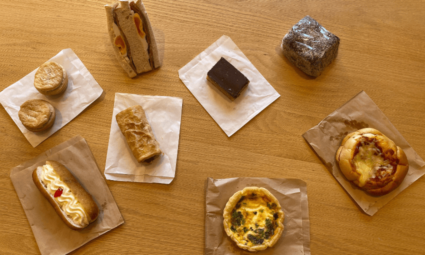 an assortment of sweet and savoury items from a classic bakery, laid out on a wooden table