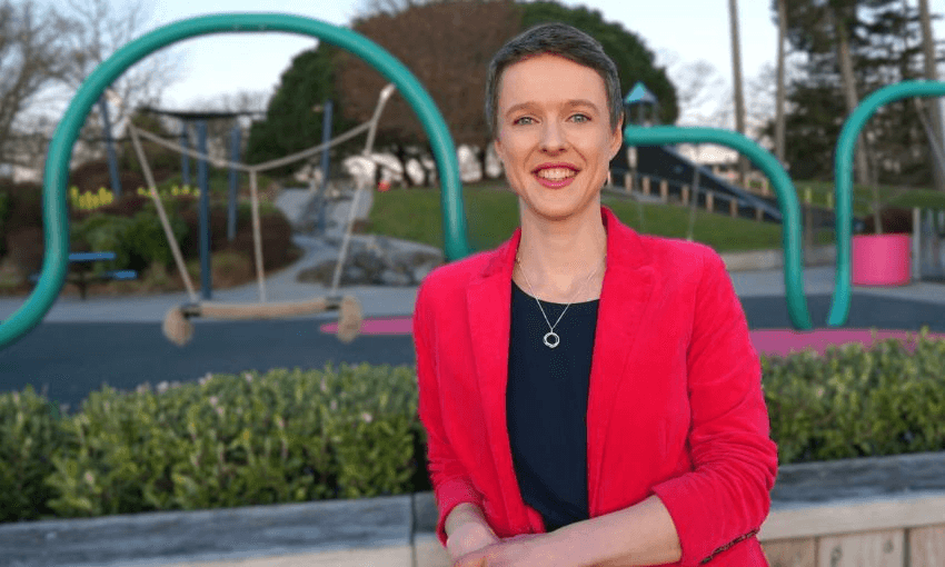 Sarah Thomson smiles in front of a children's playground.