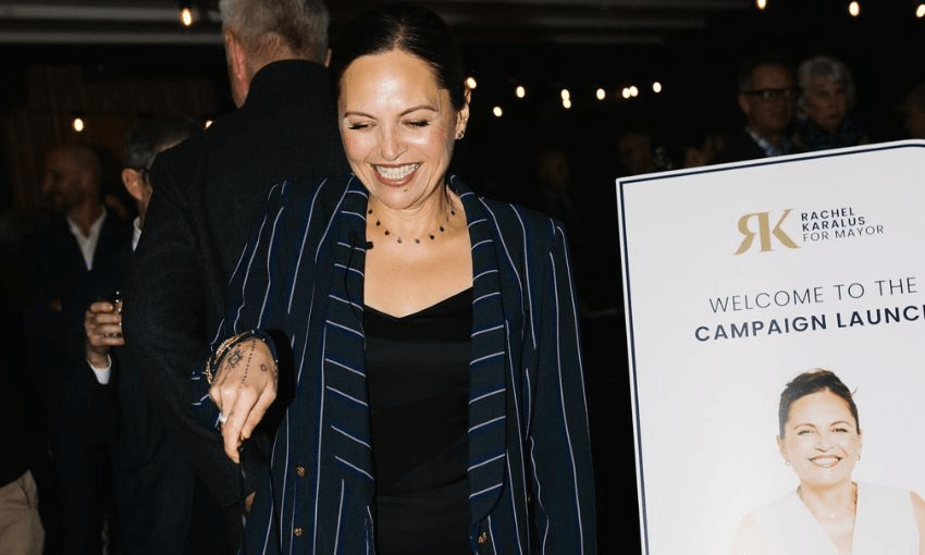 Rachel Karalus smiles at her mayoral campaign launch while cutting into a cake