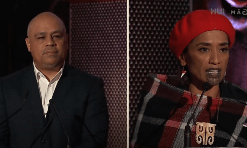 A man in a dark suit on the left and a woman in a red beret on the right