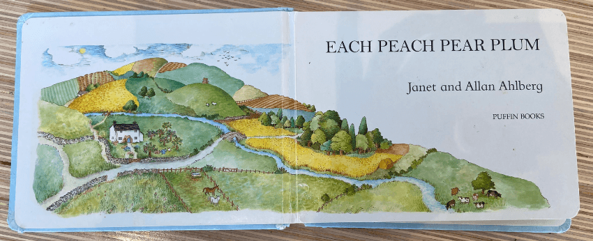 The endpapers of Each Peach Pear Plum showing an illustration of rolling countryside with a cottage.