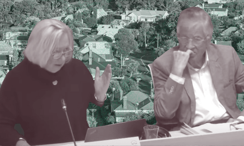 Two people sit at a desk in discussion, with one gesturing and the other resting their chin on their hand; a background of suburban houses is seen behind them.